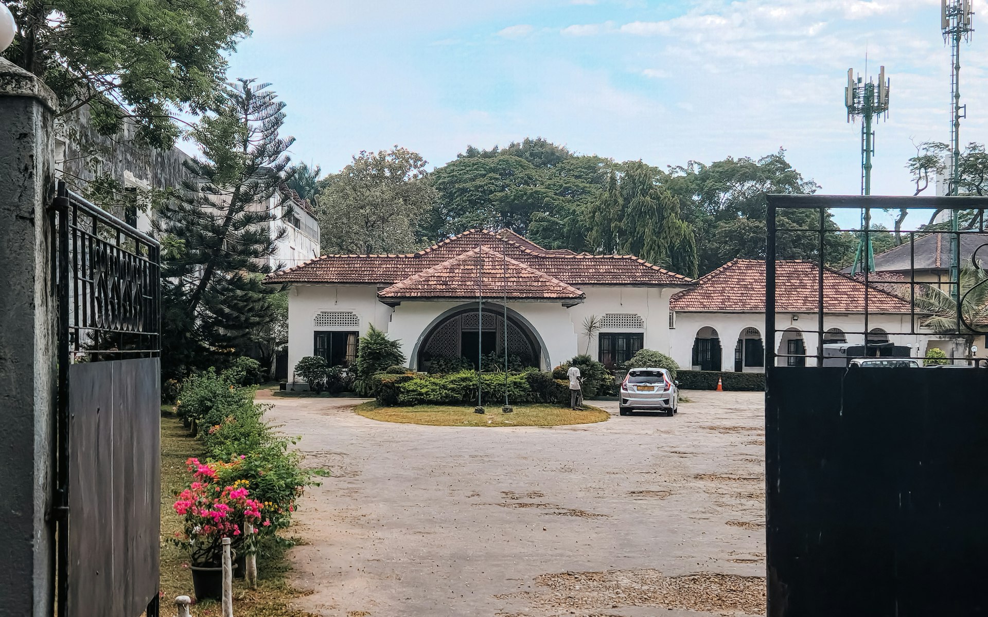 A gated driveway leading to a large house
